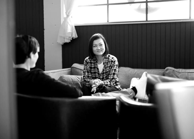 A woman sitting on a couch next to a window thinking about how to hire tech talent.