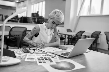 Young and beautiful creative female designer making a sketch while sitting at her workplace in the office. Web design. Creative occupation. Business and career. UX UI design