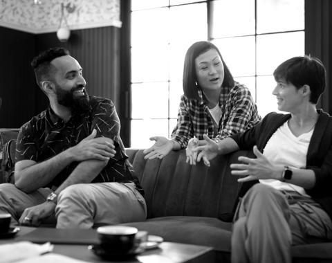 A group of people sit on a couch and talk about tech skills training.