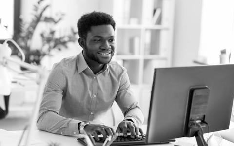 business, people and technology concept - african american businessman with computer working at office