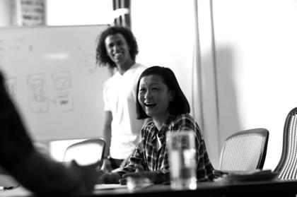 A group of people surrounding a table talking about various tech skills.