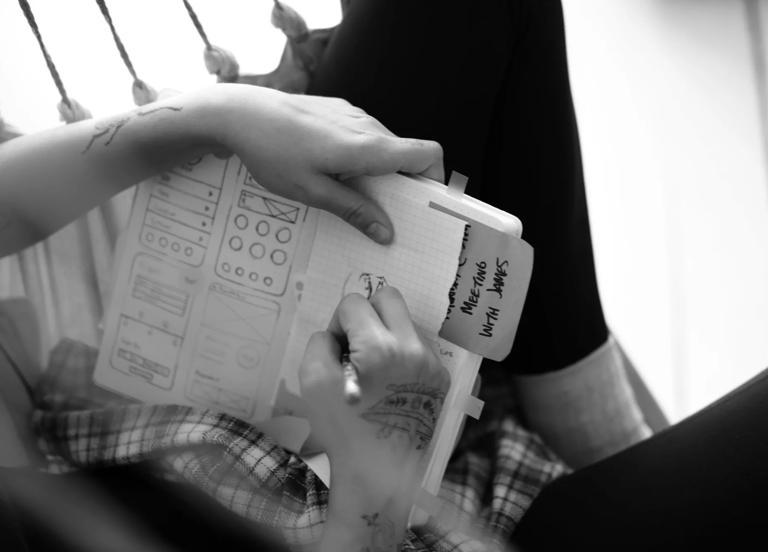 A person holding a notebook taking notes on tech skills training.