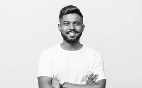 Indian handsome young man standing with hands folded against white background