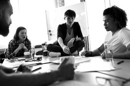 A group of people talk about tech skills training as they sit at a table.